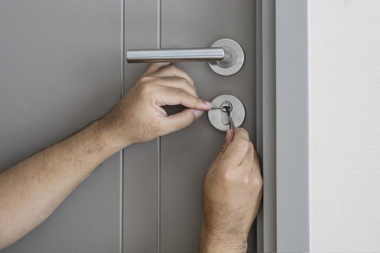 Skilled locksmith picking a door lock